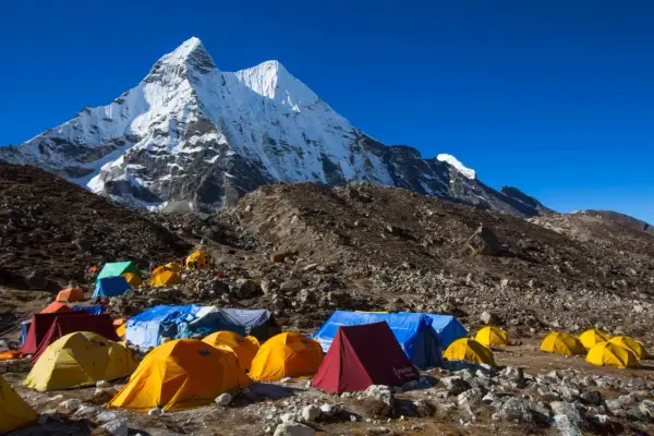Obóz pod majestatycznym szczytem Karakorum. Kolorowe namioty rozstawione na kamienistym zboczu, gotowe na przyjęcie alpinistów.