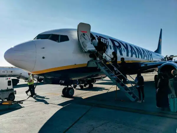Ryanair samolot, pasażerowie wsiadają. Pamiętaj o zasadach, jak przewozić leki w samolocie Ryanair, by podróż przebiegła sprawnie.