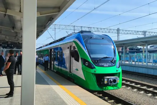 Nowy pociąg na trasie Rzeszów czeka na pasażerów. Zielono-niebieski skład stoi na peronie.