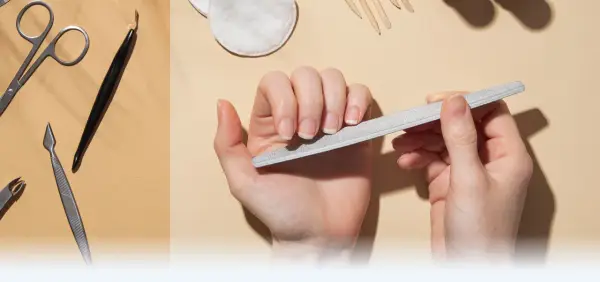 Dłonie pielęgnują paznokcie, używając pilnika. W tle widać narzędzia do manicure, takie jak nożyczki i cążki, tworząc kompletny zestaw do pielęgnacji macierzy paznokcia.
