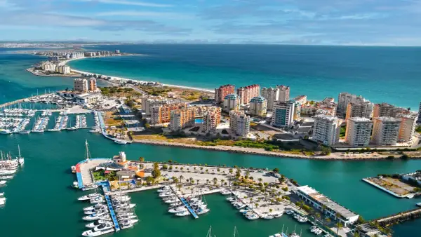 Widok na La Manga, Hiszpania: luksusowe apartamenty i pełen jachtów port nad turkusowym morzem.