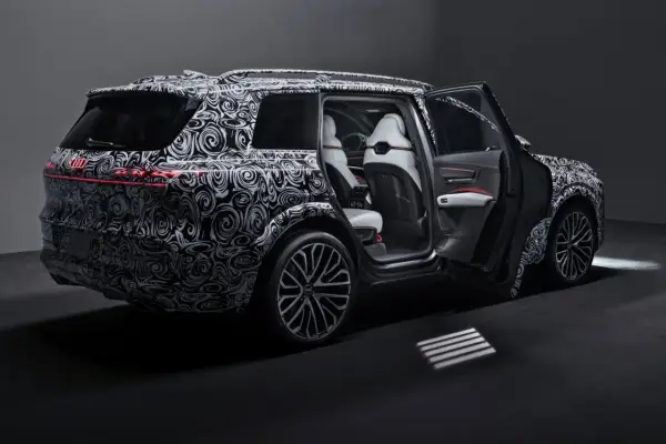 Nowy Audi Q9 w kamuflażu, z otwartymi drzwiami, prezentuje luksusowe wnętrze. Czekamy na jego cenę i premierę!