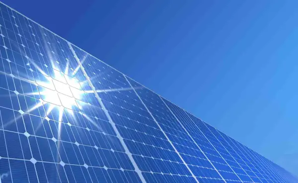 Błyszczące panele słoneczne pod błękitnym niebem. Słońce odbija się od nich, tworząc efektowny blask. To przyszłość energii, a ncbr co to? To Narodowe Centrum Badań i Rozwoju, które wspiera innowacje.