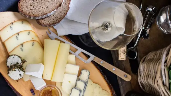Deska serów z chlebem i kieliszkiem wina, idealna do degustacji Bardolino Chiaretto.