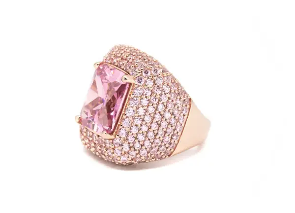 Anello in oro rosa con grande pietra rosa centrale e pavé di zirconi rosa. Il suo significato è legato all'amore e alla femminilità.