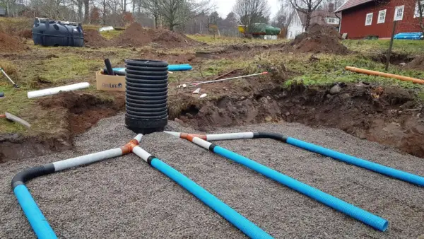 Arbetet med enskilt avlopp pågår. Grus och rör läggs ut för att hantera avloppsvatten, en viktig investering för framtiden.