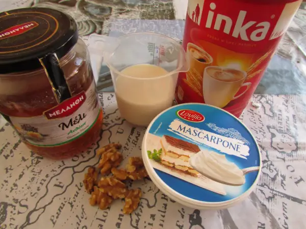 Składniki na kawę Inka z mlekiem: słoik miodu, kubek mleka, opakowanie serka mascarpone, orzechy włoskie i puszka kawy Inka.