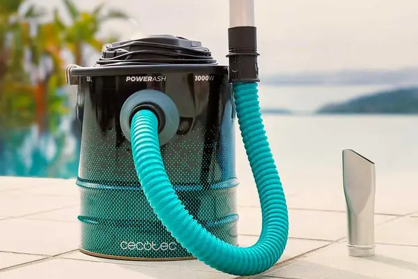 Aspirateur à cendres avec tuyau bleu et embout argenté, près d'une piscine.