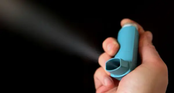 Hand hält blauen Inhalator, der Nebel versprüht. Informationen zu brimica genuair nebenwirkungen sind wichtig.