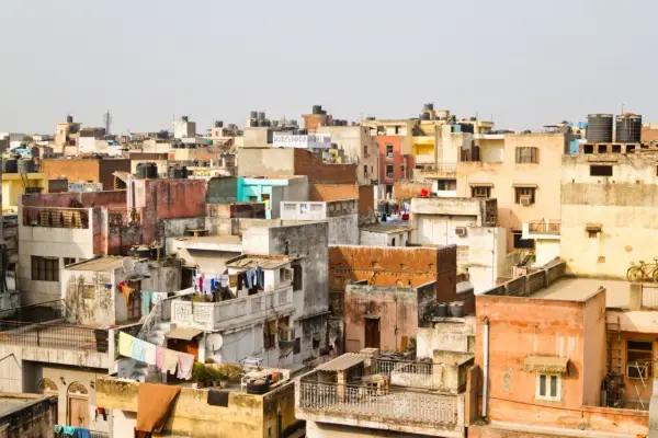 Gęsto zabudowane dachy w New Delhi, świadczące o dużej **new delhi ludność**. Widać pranie rozwieszone do suszenia i zbiorniki na wodę.