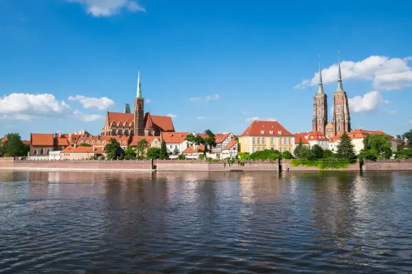 Widok na Ostrów Tumski we Wrocławiu, perłę Dolnego Śląska, z rzeką w tle.
