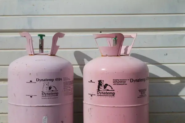 Dwie różowe butle gazowe Dynatemp 410A czekają na wymianę.