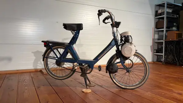 Velosolex antigua azul, un clásico de dos ruedas con motor, lista para revivir viejas aventuras.