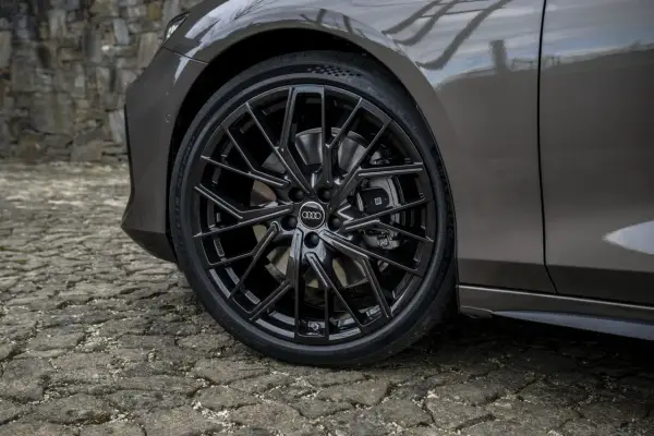 Błyszczące, czarne felgi Audi z homologacją opon Michelin Pilot Sport 5 na kamiennej nawierzchni.