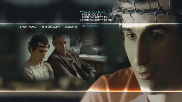 Mężczyzna z koroną cierniową na głowie, jakby wszyscy jesteśmy chrystusami, siedzi obok starszego mężczyzny. Menu filmu wyświetla opcje.