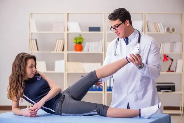 Fizjoterapeuta wykonuje ćwiczenia z pacjentką w gabinecie.