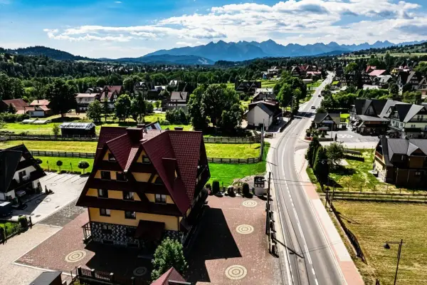 Malownicze tatrzańskie miejscowości z charakterystyczną architekturą i górami w tle.