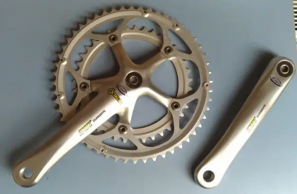 Srebrna korba rowerowa Shimano 105 z technologią Hollowtech 1 i zębatkami.