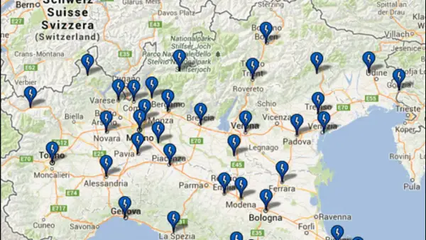 Mappa con segnaposto blu a forma di fulmine che indicano la posizione di colonnine elettriche in autostrada tra Svizzera e Italia.