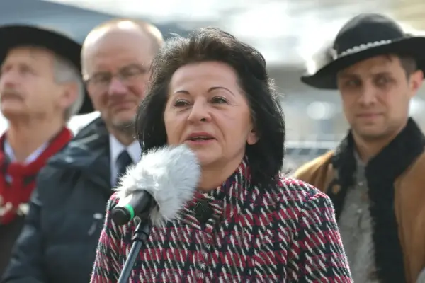 Kobieta przemawia do mikrofonu, w tle mężczyźni. Czy to ukryty majątek w nieruchomościach znanej posłanki Prawa i Sprawiedliwości?