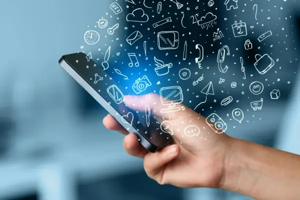 En hand håller en mobil med en mängd ikoner som svävar ut, som ett digitalt måttband i mobilen som mäter allt från väder till kommunikation.