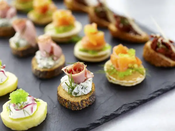 Deliciosos entrantes navideños: canapés variados con salmón, jamón, queso y patata. ¡Perfectos para celebrar!