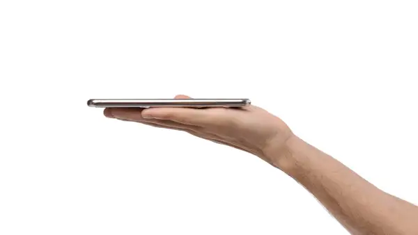 Dłoń trzyma cienki, srebrny smartfon. Może to być nowy model, np. kierunkowy 95 Polska.