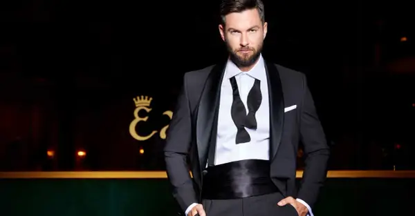 Ein Mann in einem Smoking, der die Frage "was ist ein smoking" beantwortet. Klassisch, elegant und bereit für den roten Teppich.