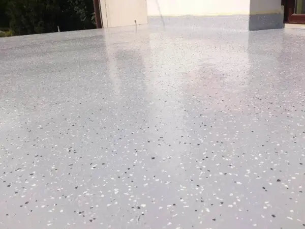 Nowoczesny kamienny dywan koszt 1m2. Jasnoszara posadzka z drobnymi, kolorowymi płatkami, idealna na taras lub balkon.