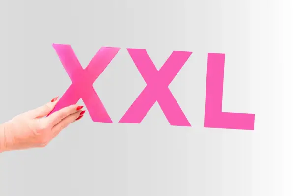 Dłoń z czerwonymi paznokciami trzyma literę "X", obok widnieją kolejne litery "XXL". Czy to rozmiar 50 jaki to rozmiar damski?