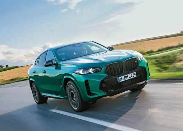 Zielony BMW X6 M Competition, jakby wyłaniał się z krajobrazu, niczym **formentor** w drodze na szczyt.
