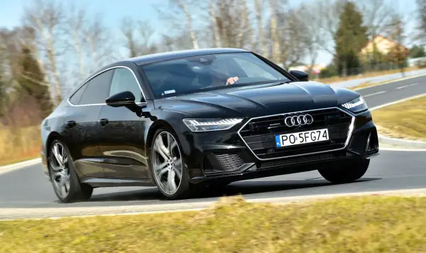 Czarny Audi A7 na drodze. Sprawdź aktualną audi a7 cena i możliwości tego sportowego sedana.