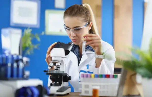 Studentka na biotechnologia studia bada próbkę pod mikroskopem.