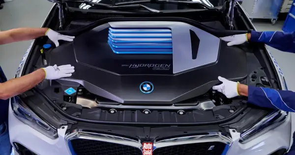 Ręce w białych rękawiczkach montują osłonę silnika BMW i Hydrogen Fuel Cell.