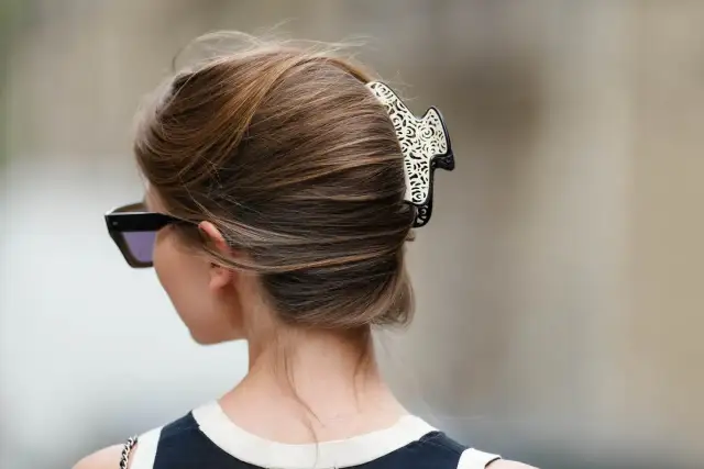 Elegancki french twist z ozdobną spinką, podkreślający szyję i okulary przeciwsłoneczne.