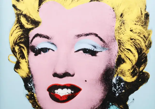 Ikona popkultury w stylu Andy'ego Warhola. Marilyn Monroe z żółtymi włosami, różową cerą i wyrazistymi ustami.