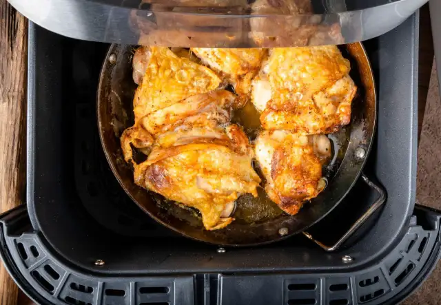 Pechuga de pollo dorada y jugosa cocinándose en una freidora de aire.