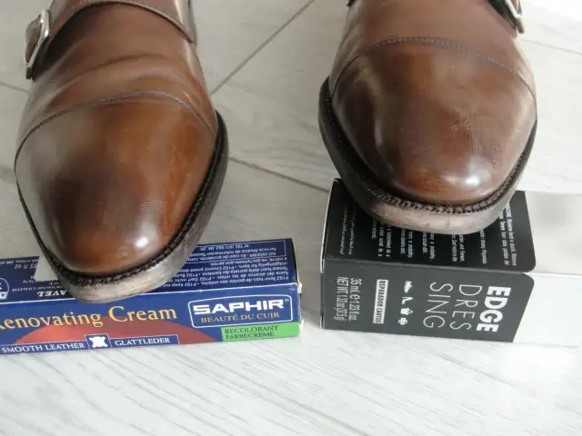 Brązowe buty męskie z klamrą, obok kremu do renowacji i preparatu do krawędzi.