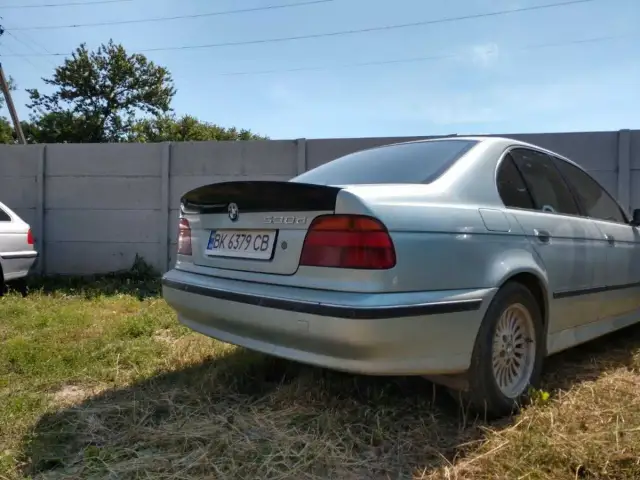 Srebrne BMW E39 z czarnym spoilerem na klapie bagażnika.