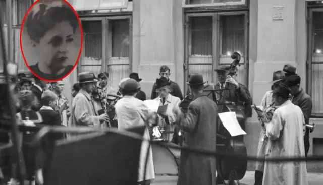 Kobieta w okręgu, zespół grający na ulicy. Muzycy z instrumentami, jakby po pracy, jak siekiera motyka, w tle budynek.