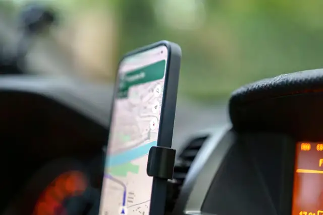 Telefon z mapą na ekranie, zamontowany w samochodzie. Ułatwia nawigację na telefon podczas podróży.