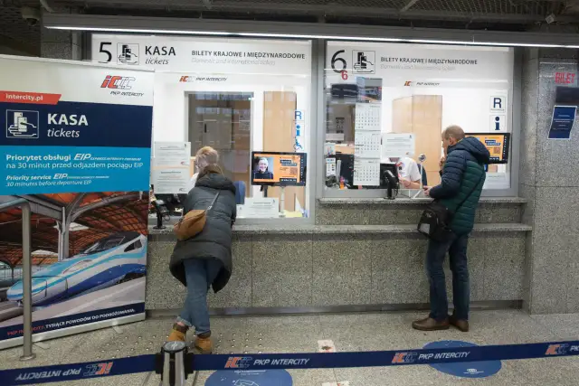 Kasa PKP Intercity w Poznaniu, gdzie kupisz bilety na pociąg do Warszawy. Ludzie stoją w kolejce do okienka.