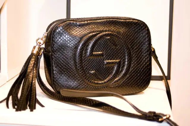 Czarna, pikowana torebka Gucci z wytłoczonym logo i frędzlami. Klasyczne, stylowe modele torebek Gucci.