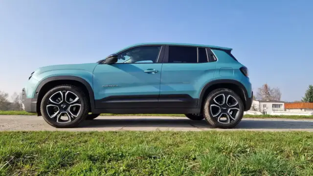 Turkusowy Jeep Avenger na tle błękitnego nieba. Wiele osób szuka jeep avenger opinie, by poznać ten model.