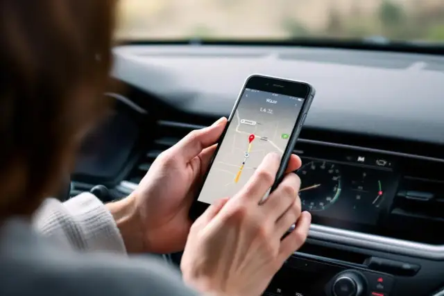 Une personne utilise son smartphone pour naviguer avec Waze. L'application affiche une carte avec un itinéraire. C'est une aide pour savoir comment installer Waze sur mon portable.
