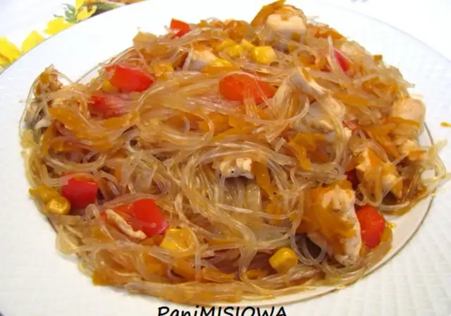 Pyszny makaron sojowy smażony z kurczakiem, papryką i kukurydzą. Danie wygląda apetycznie i kolorowo.