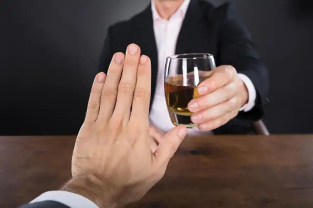 Dłoń odrzuca kieliszek z wódką, świadomie unikając pustych kalorii.