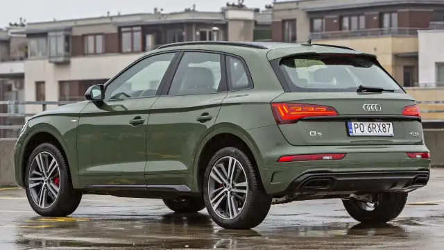 Zielony Audi Q5 na mokrym parkingu. Poznaj jego imponujące audi q5 wymiary i możliwości.