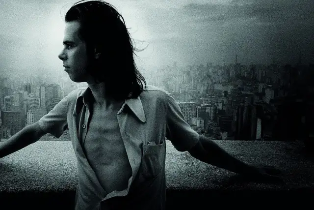 Młody Nick Cave, z rozwianymi włosami, spogląda na miasto. Jego muzyka, jak ten widok, pełna jest mroku i piękna.