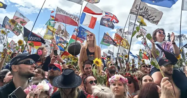 Tłum na festiwalu Poland Rock 2026, z flagami i słonecznikami. Ludzie cieszą się muzyką i atmosferą.